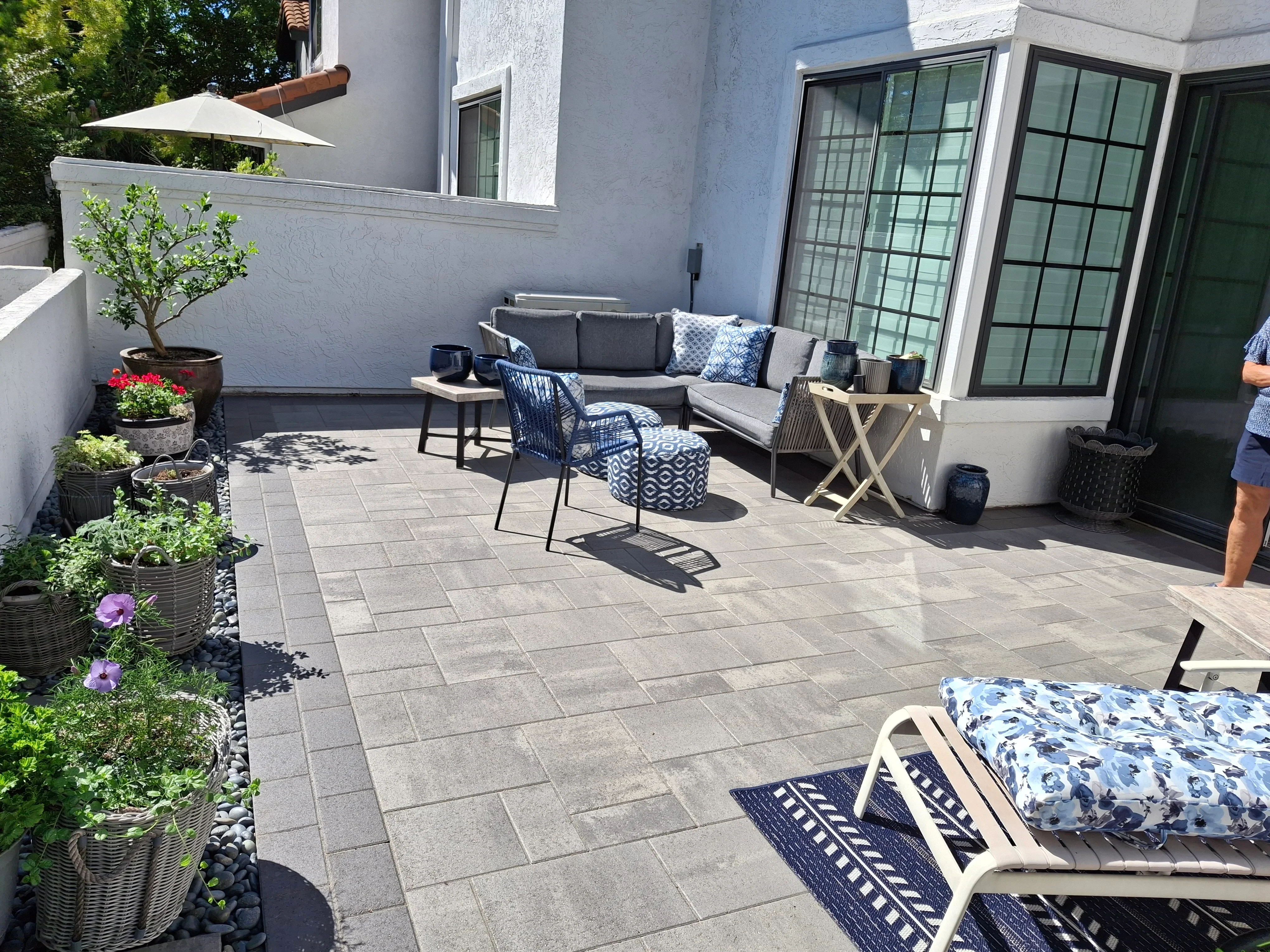 Gray permeable pavers in running bond pattern with planting beds and gravel border