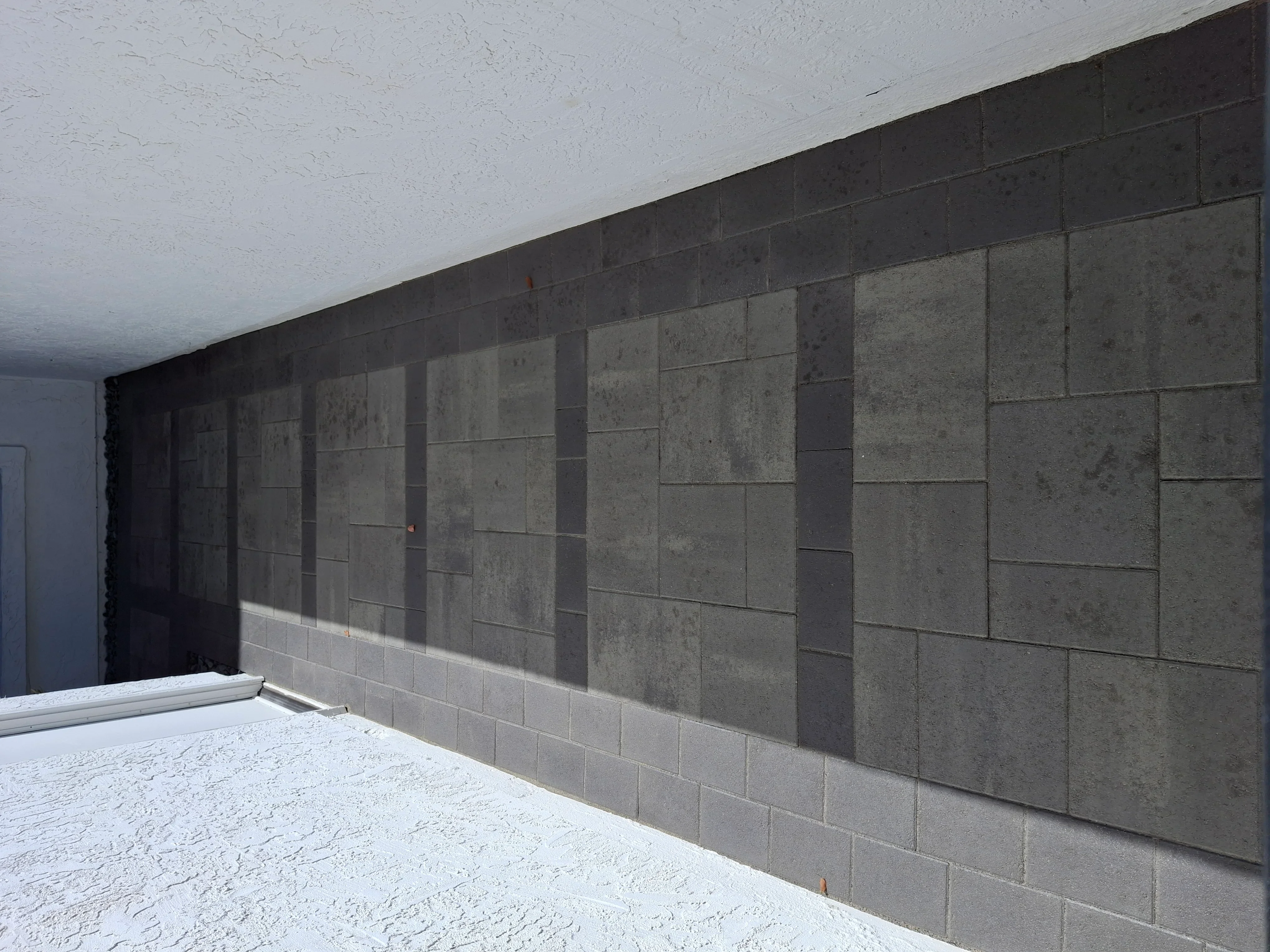 Concrete block retaining wall with running bond pattern and white base course