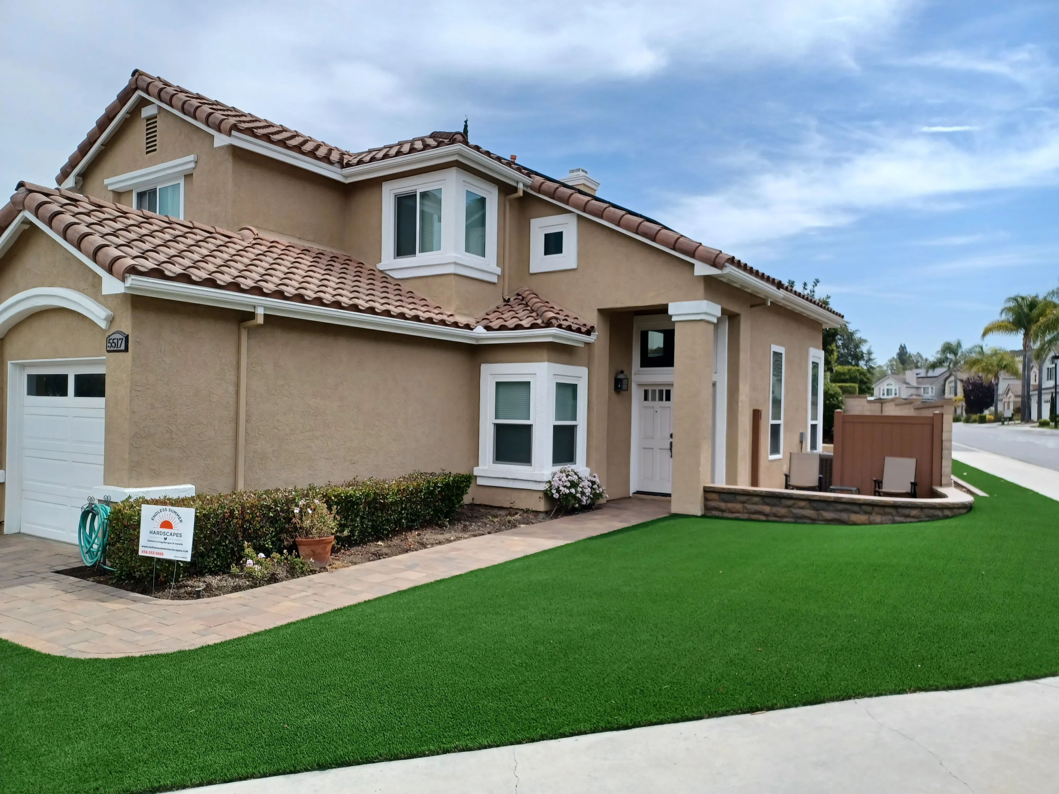 Synthetic turf lawn with clay brick paver walkway and landscape bed edging