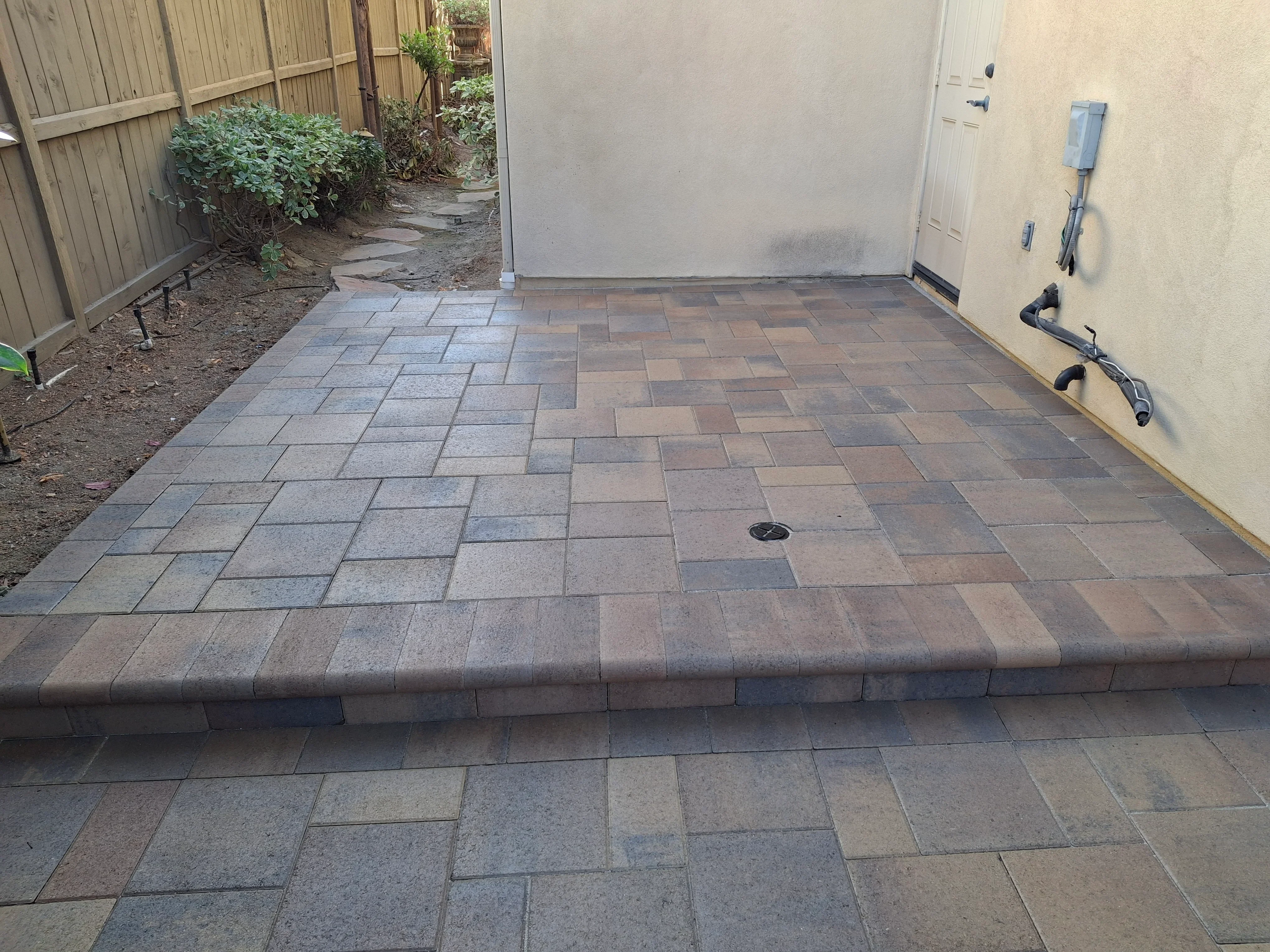 Permeable paver patio with charcoal and brown tones, running bond pattern, and integrated drainage system