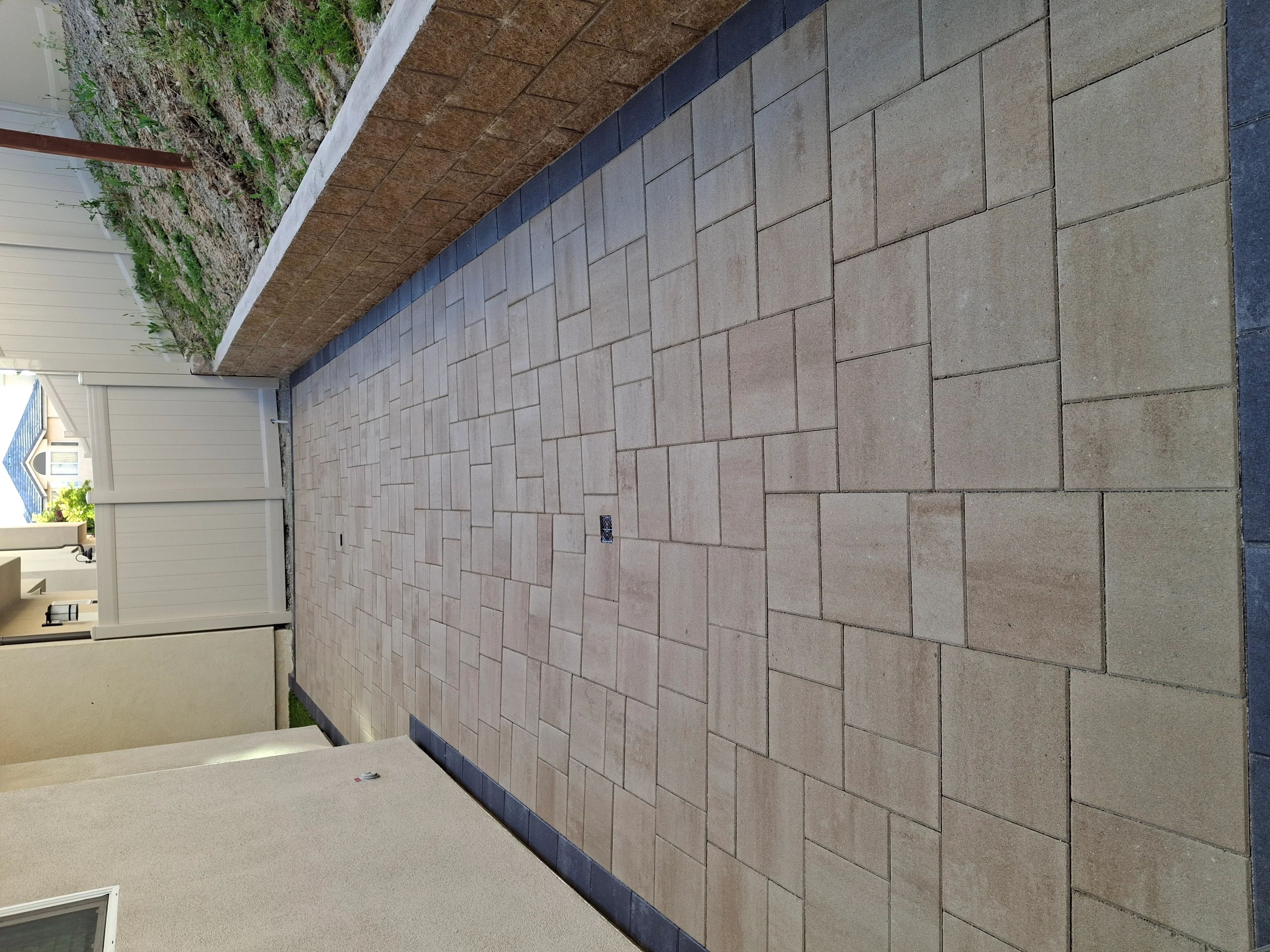 Permeable concrete pavers in running bond pattern with dark border edging on residential driveway