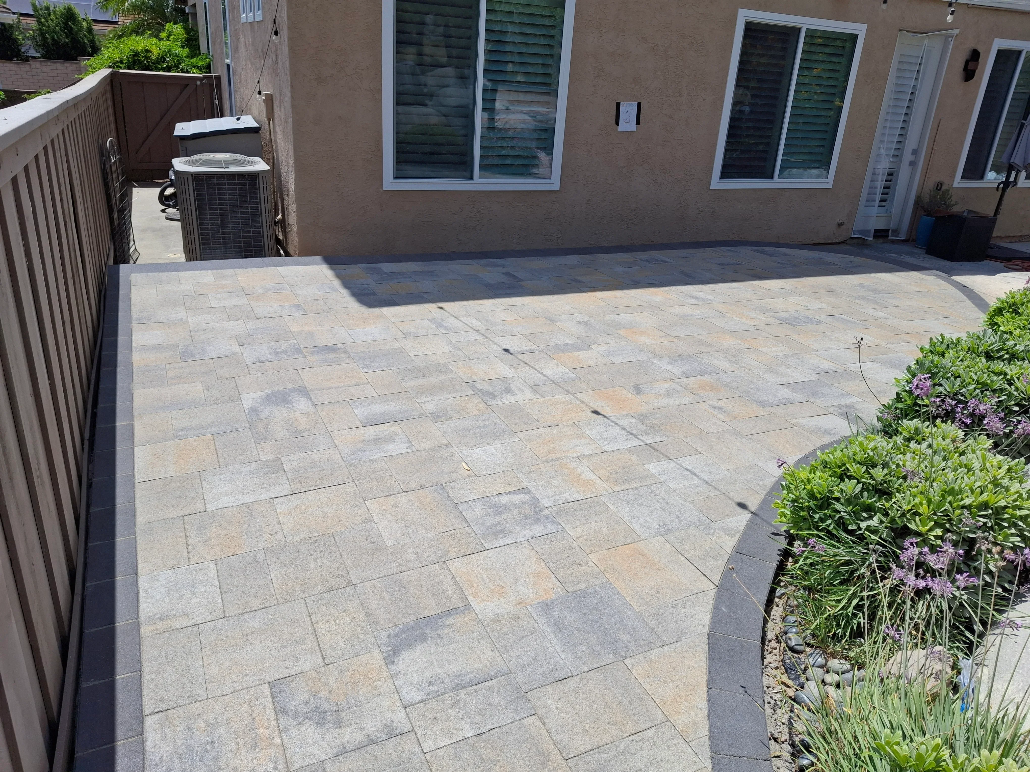 Concrete permeable pavers in herringbone pattern with dark border edging on residential patio