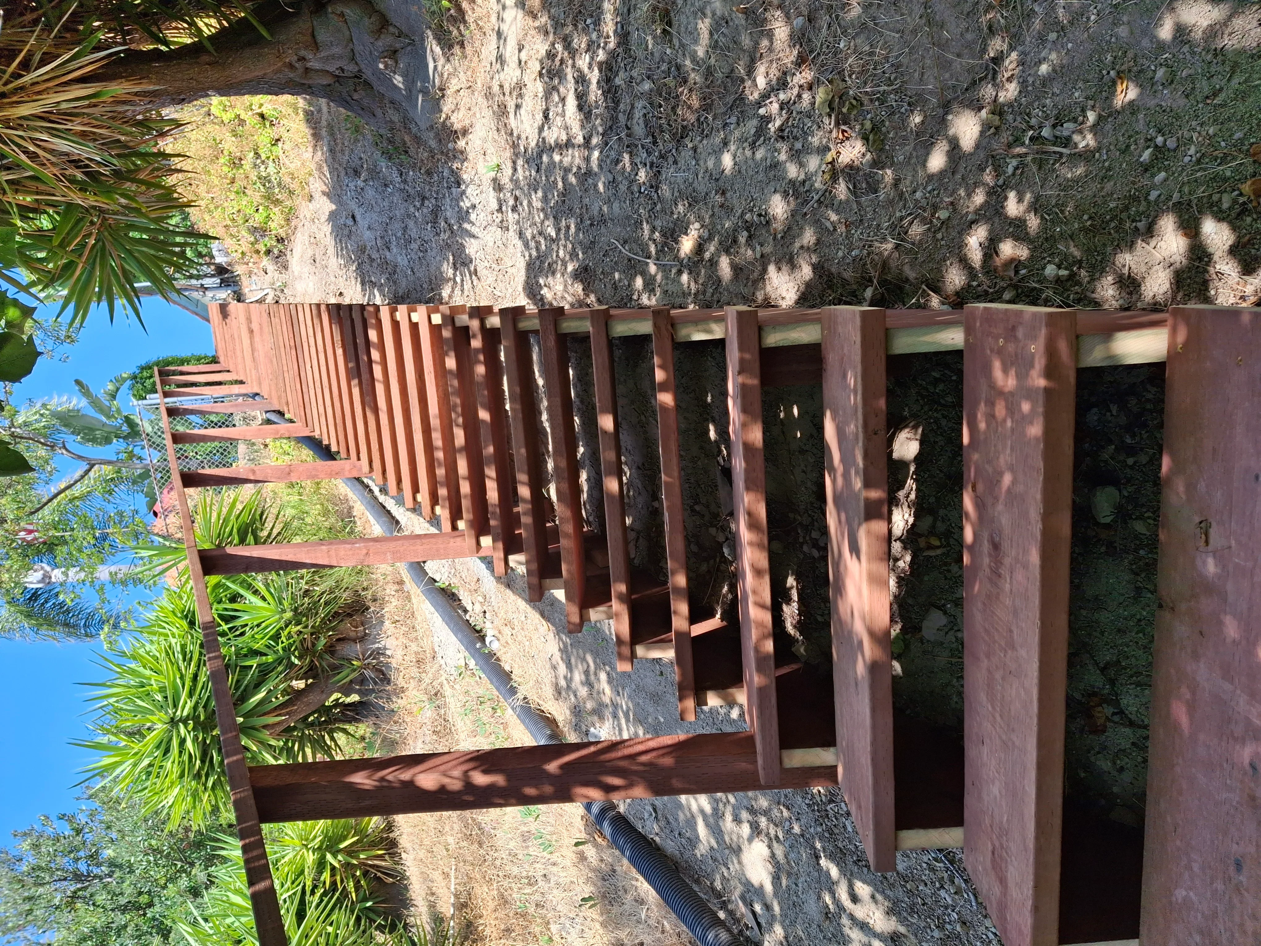 Timber deck with horizontal metal railings on concrete foundation, coastal setting