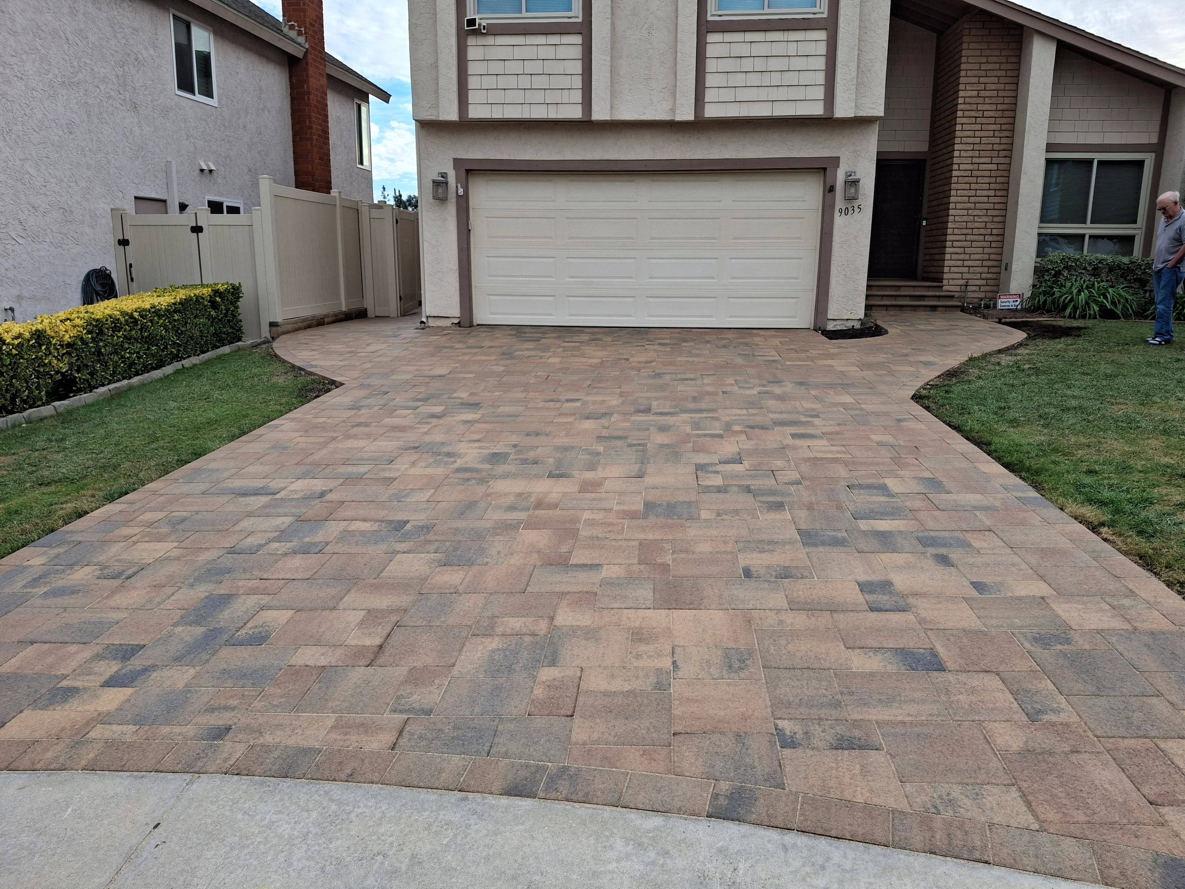 Multi-colored permeable brick pavers in herringbone pattern on residential driveway