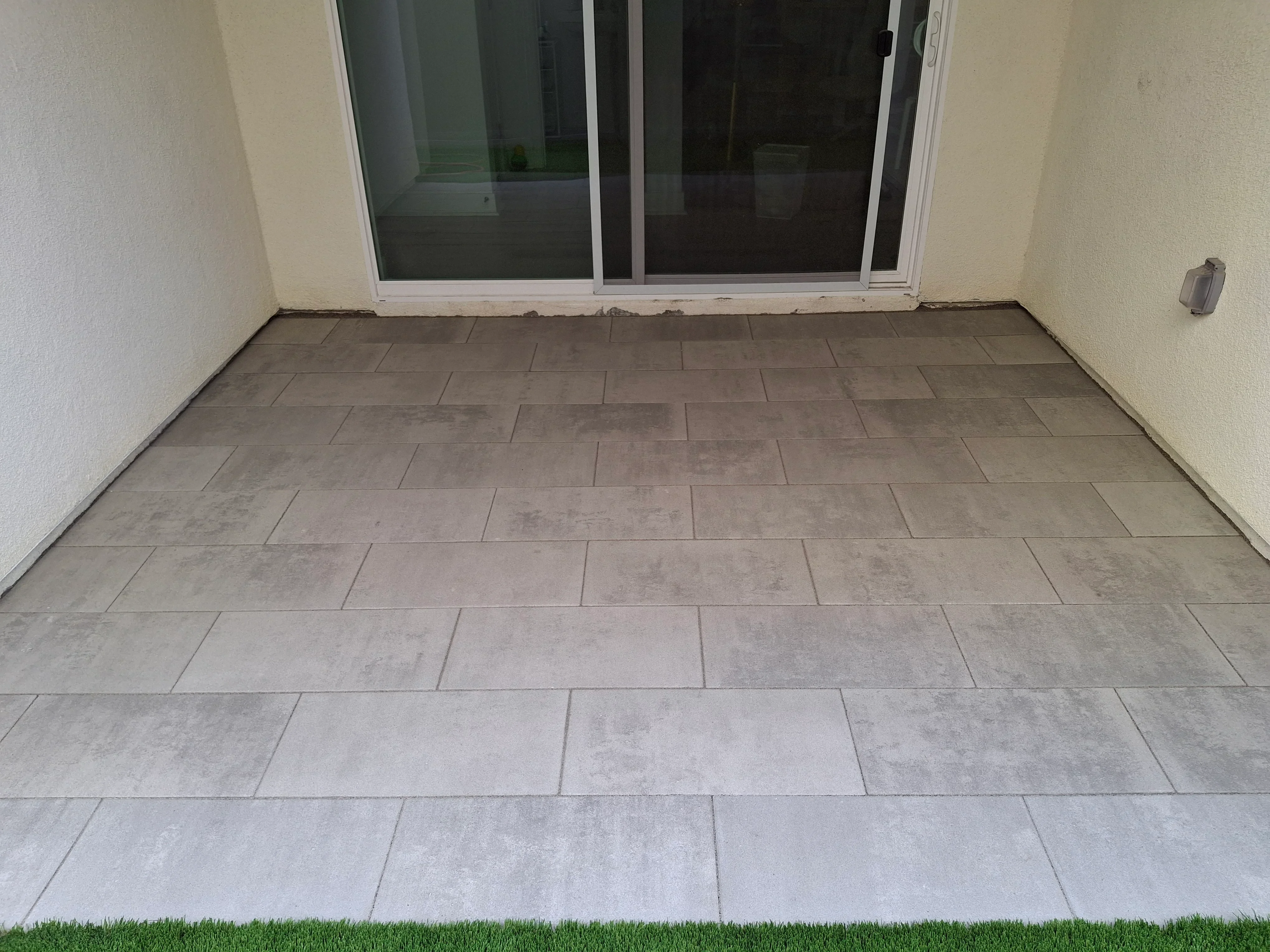 Large porcelain patio tiles in running bond pattern with uniform grout lines