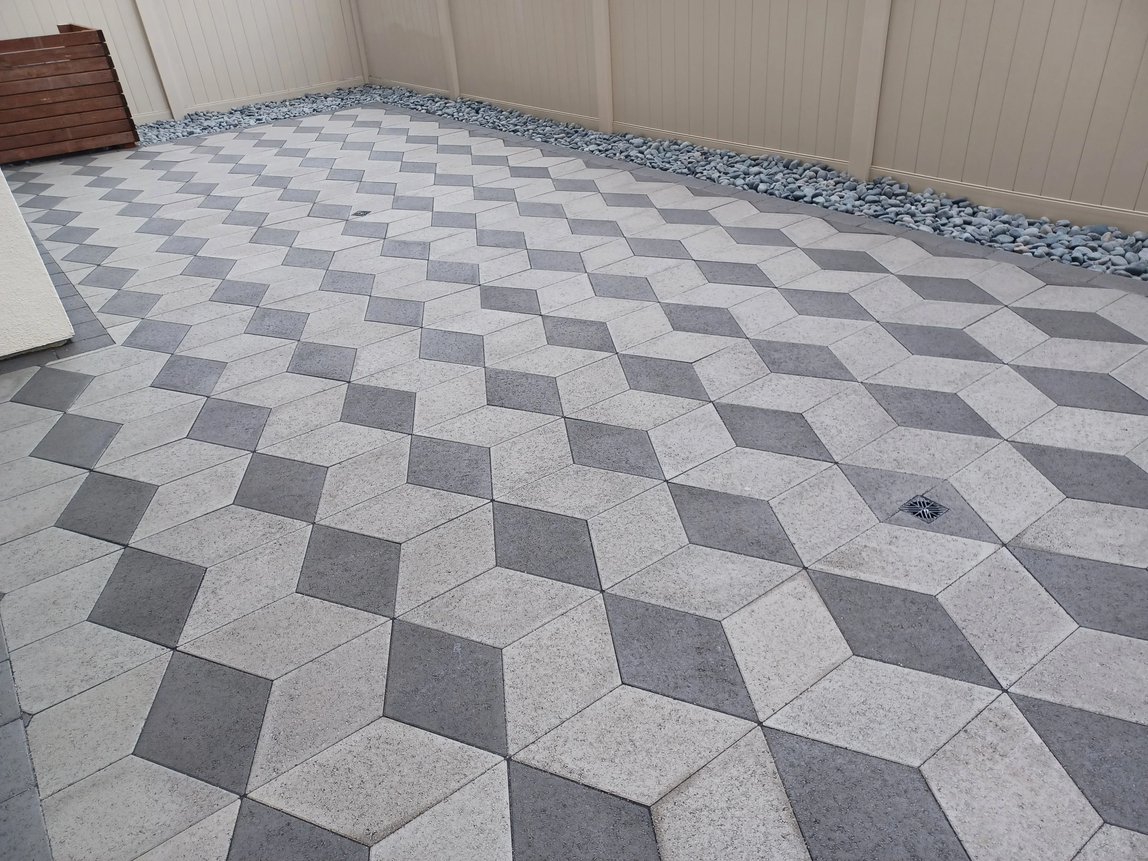 Gray and light gray 3D diamond pattern concrete pavers with gravel border and drainage