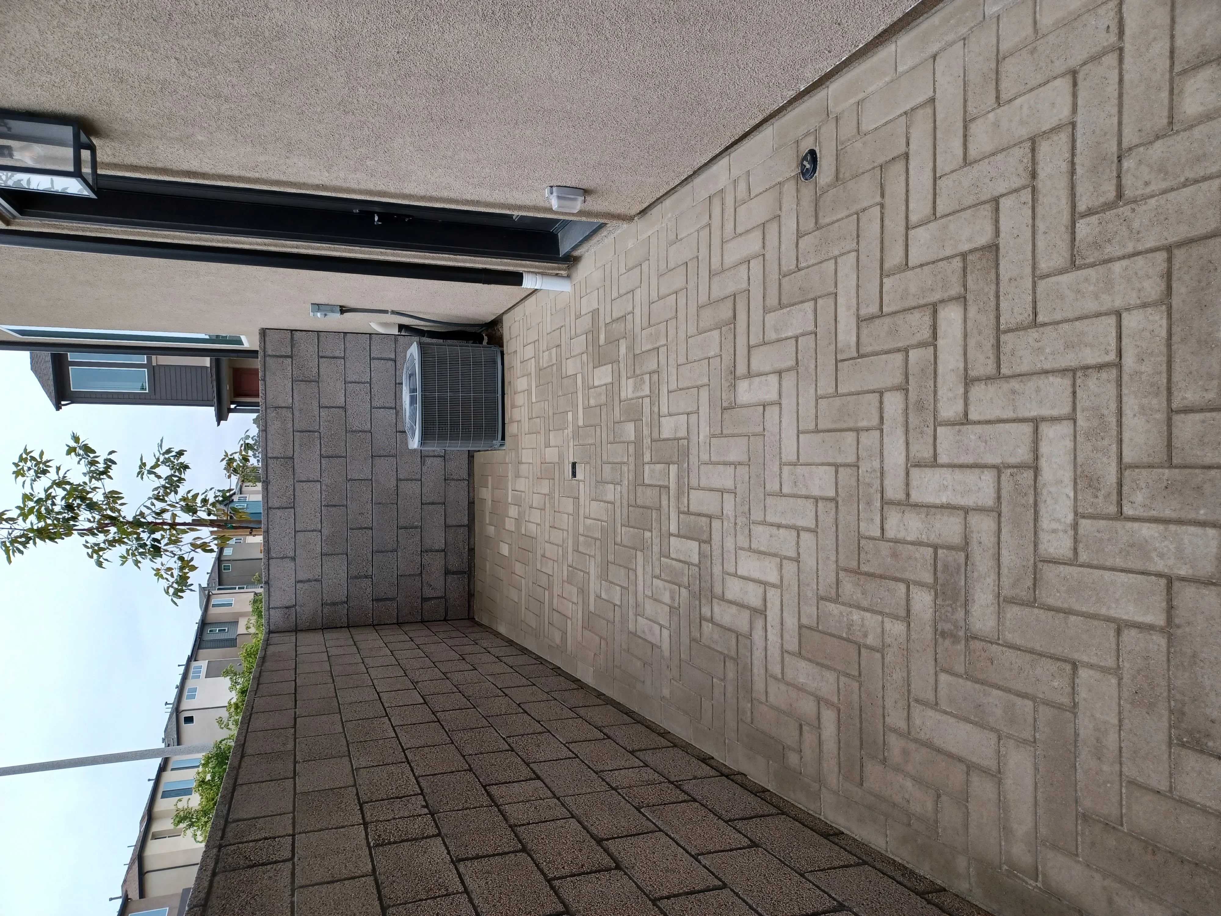 Paver patio with herringbone brick veneer walls and covered overhead structure