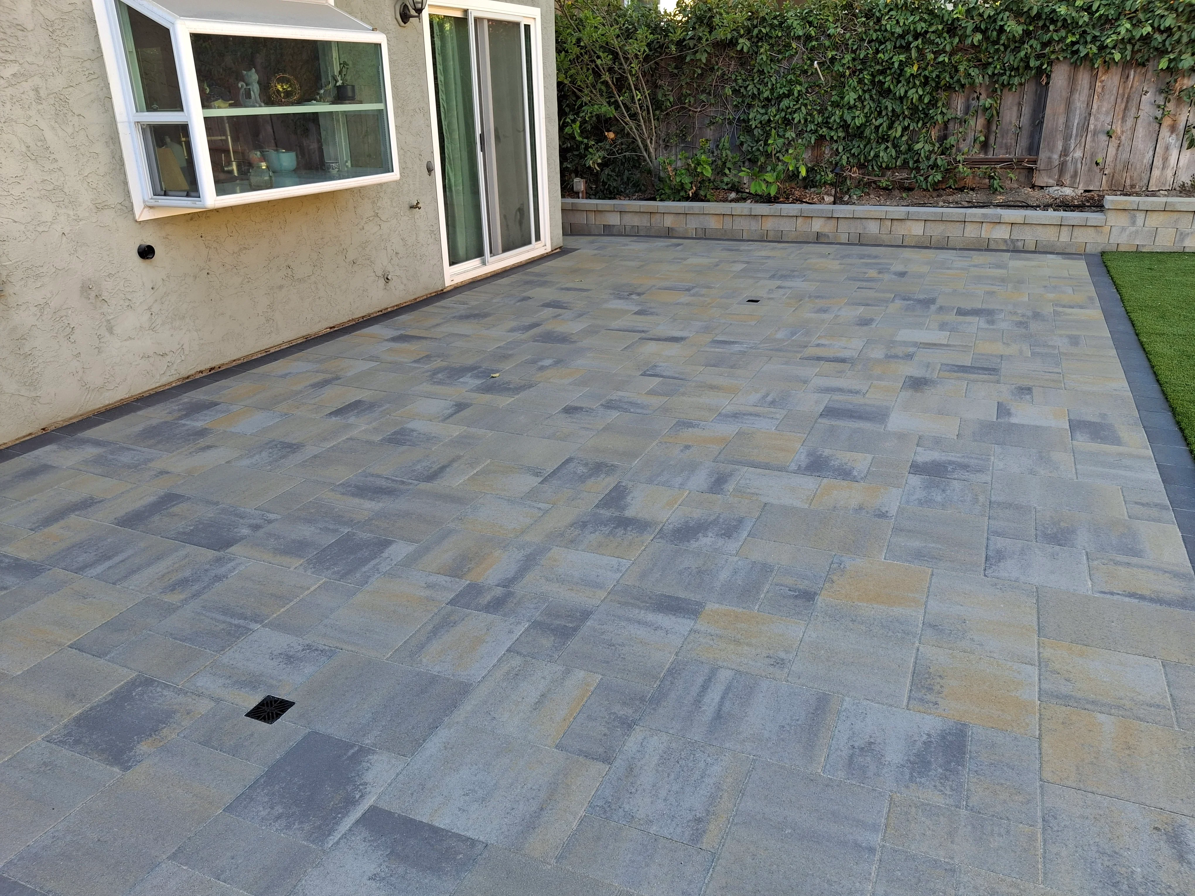 Multi-colored slate paver patio in running bond pattern with drainage system