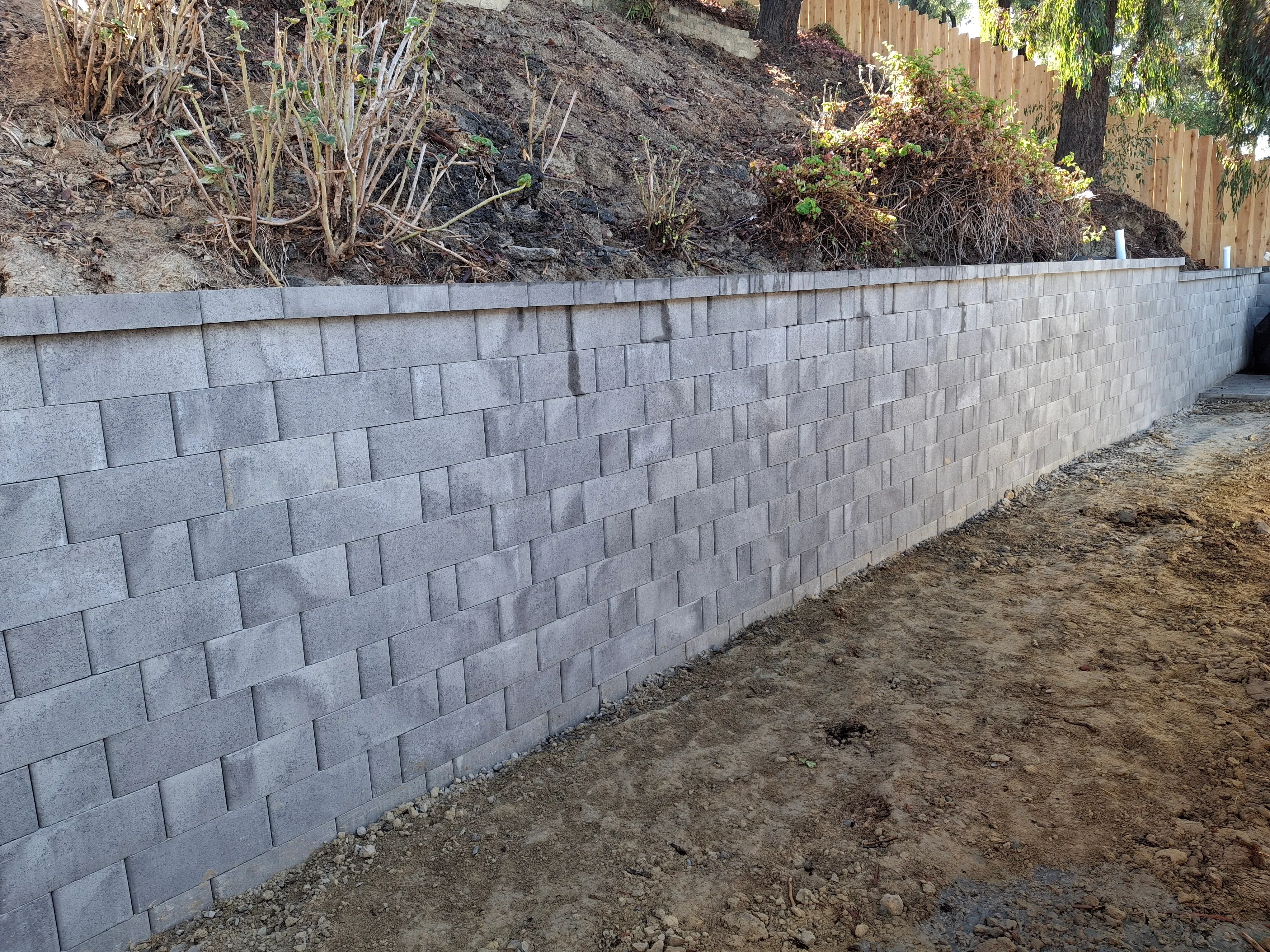 Gray concrete segmental retaining wall with running bond pattern installation