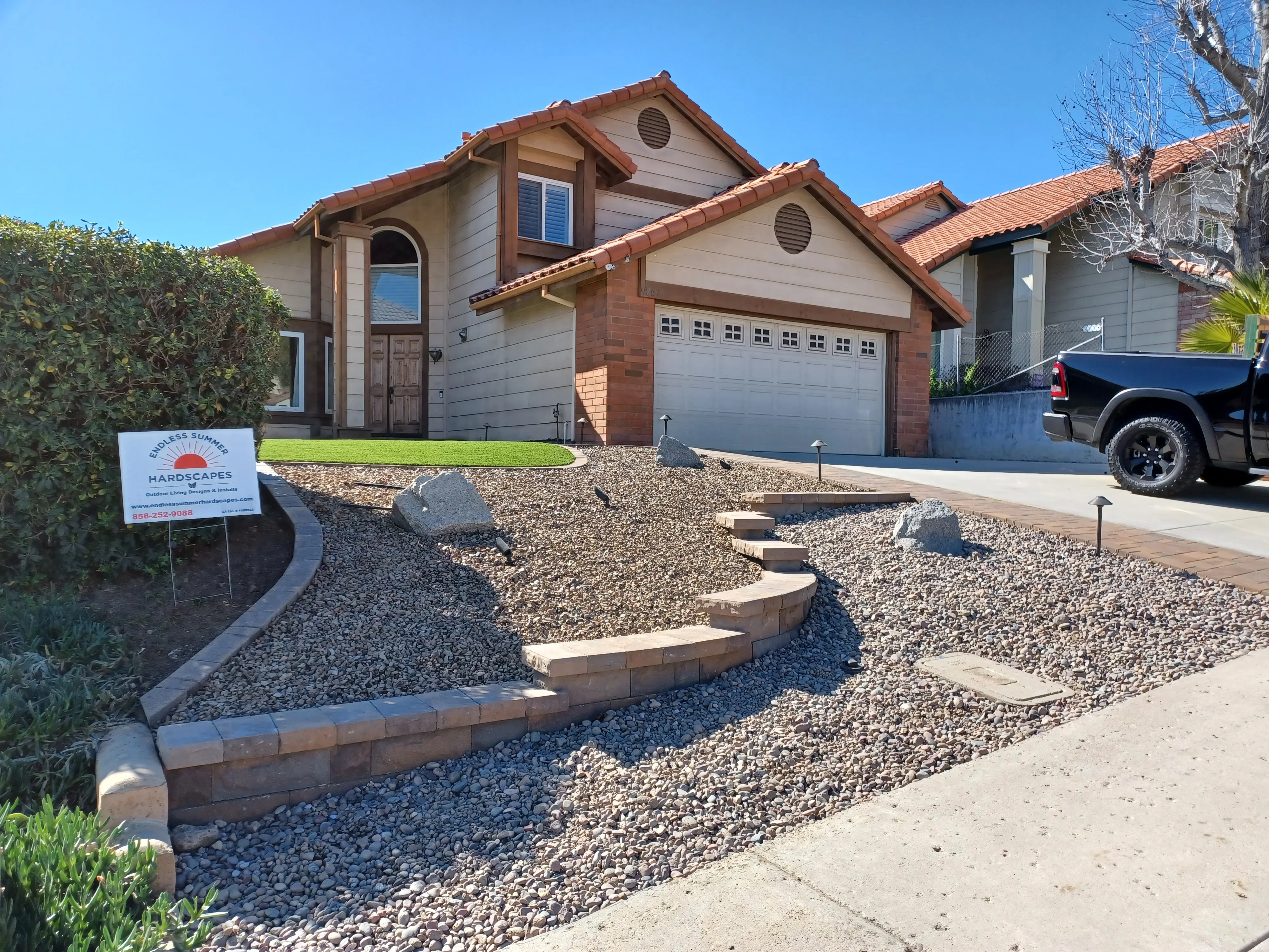 Tiered stone retaining walls with decomposed granite and stepping stones in front yard
