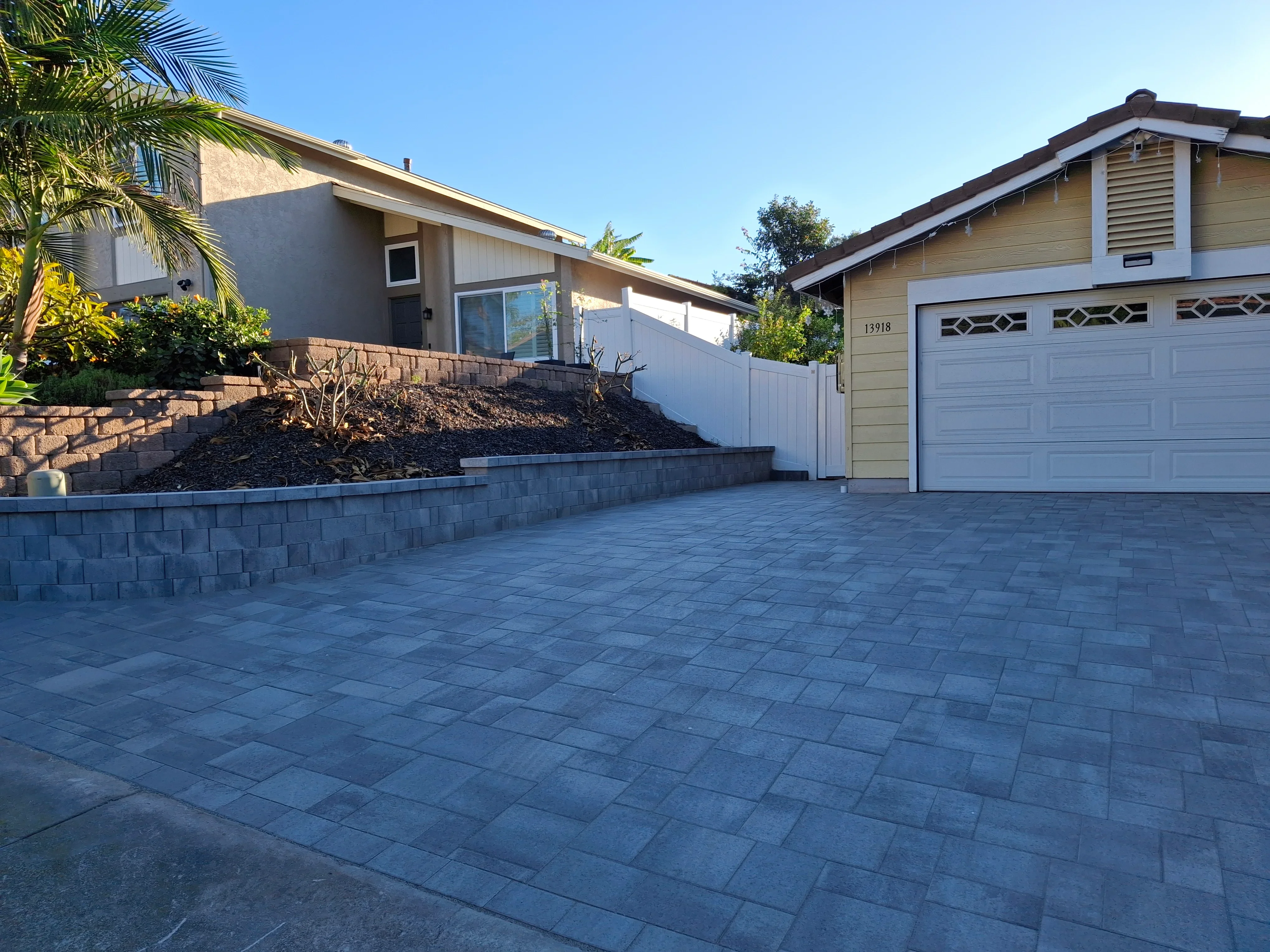 Permeable paver driveway with concrete block retaining walls and landscape integration