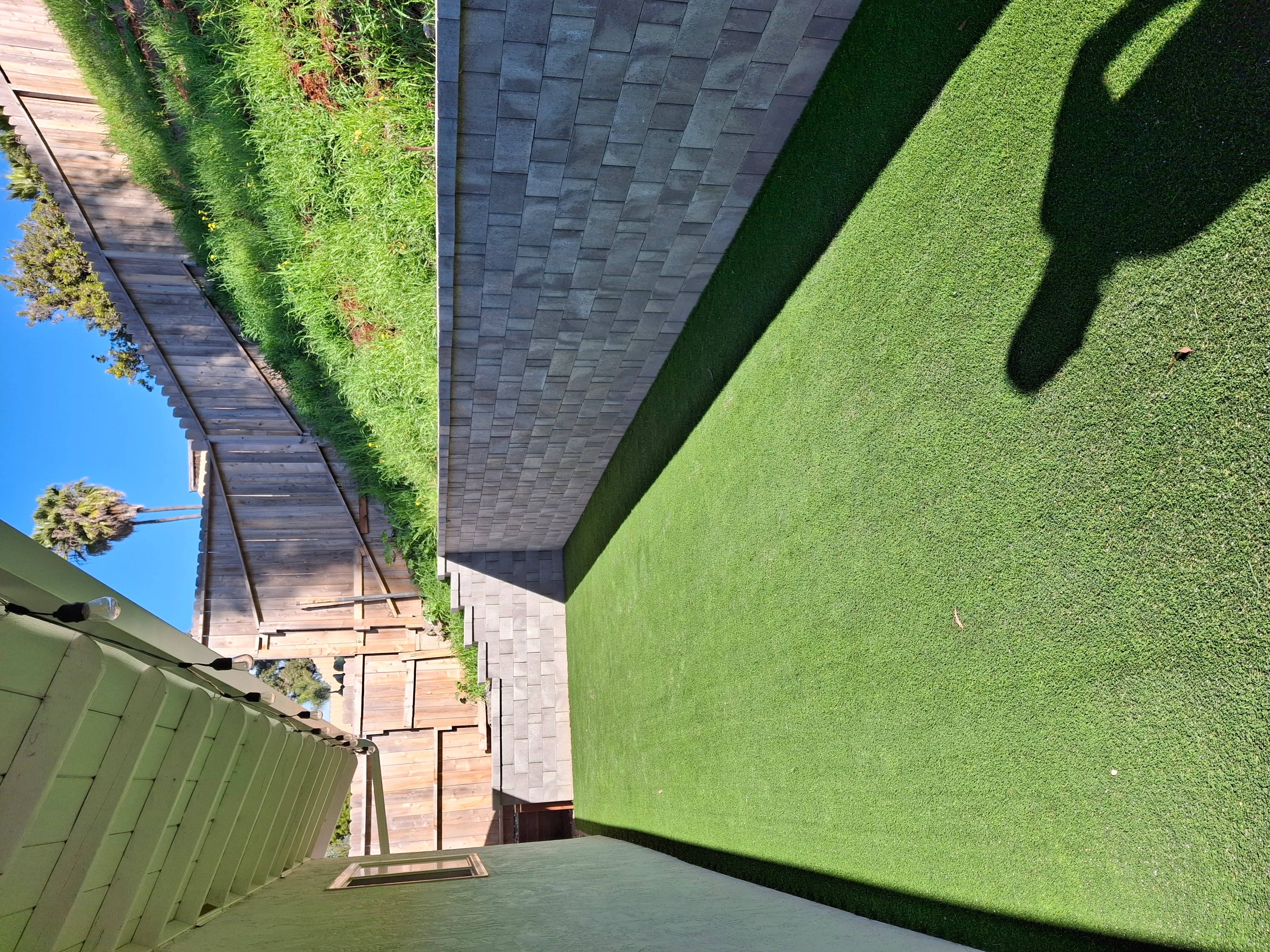 Synthetic turf yard with composite deck, metal railing, and pergola structure