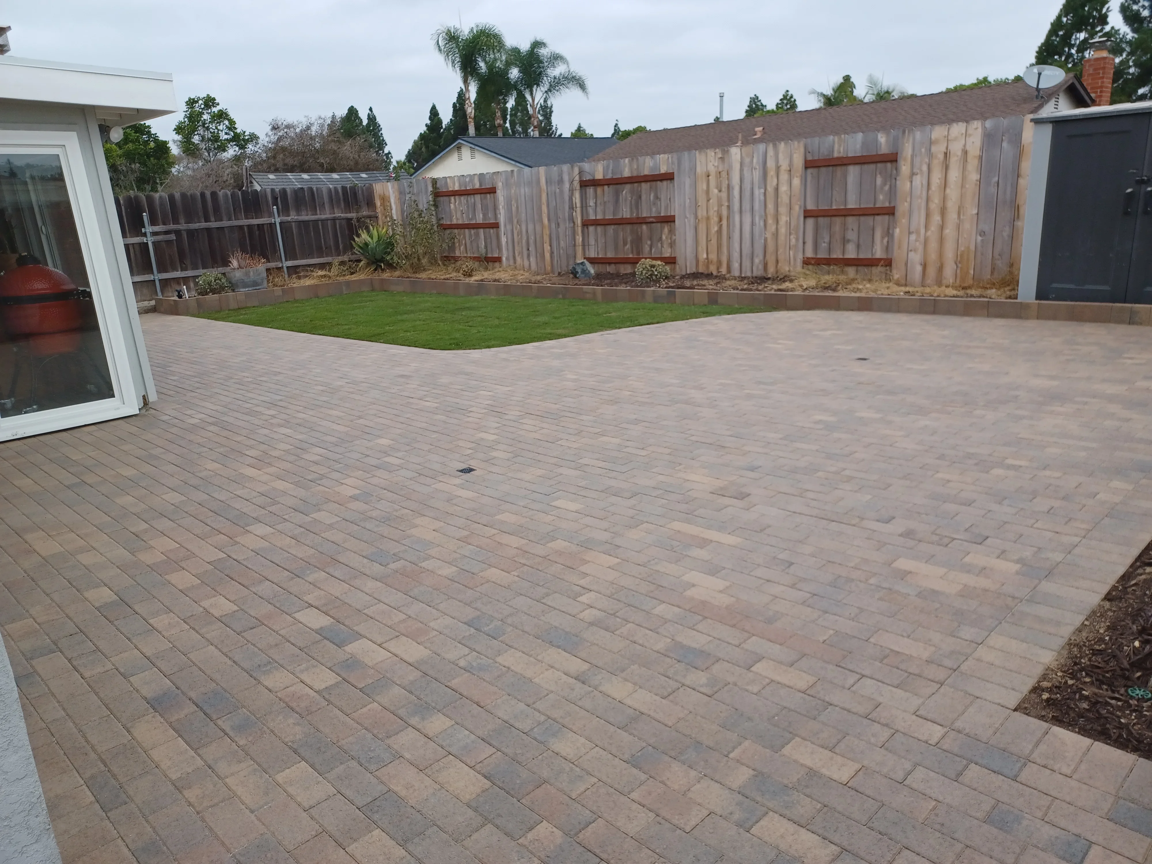 Permeable paver patio with running bond pattern and integrated lawn area