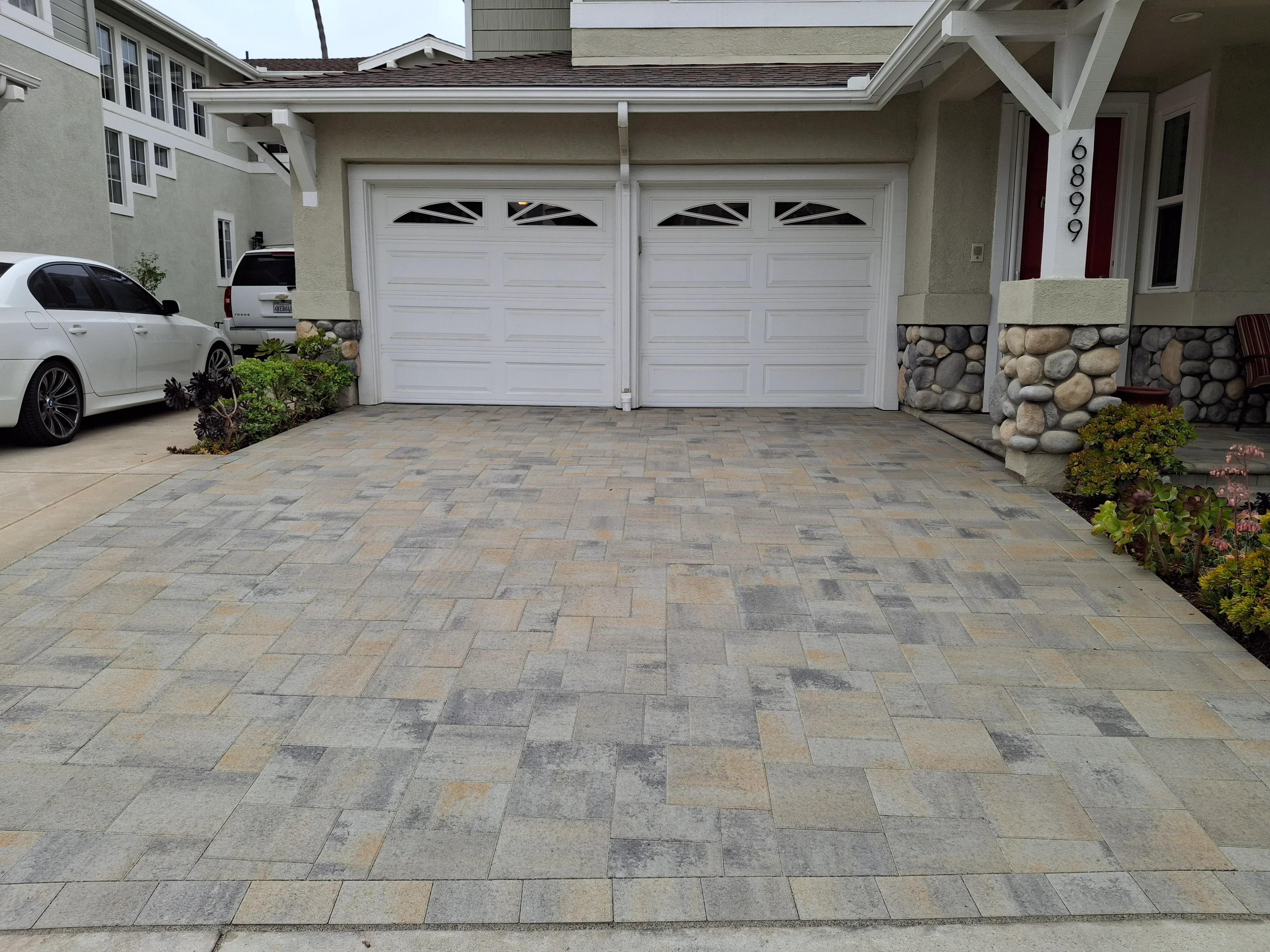 Mixed-color rectangular permeable pavers in driveway with herringbone pattern layout