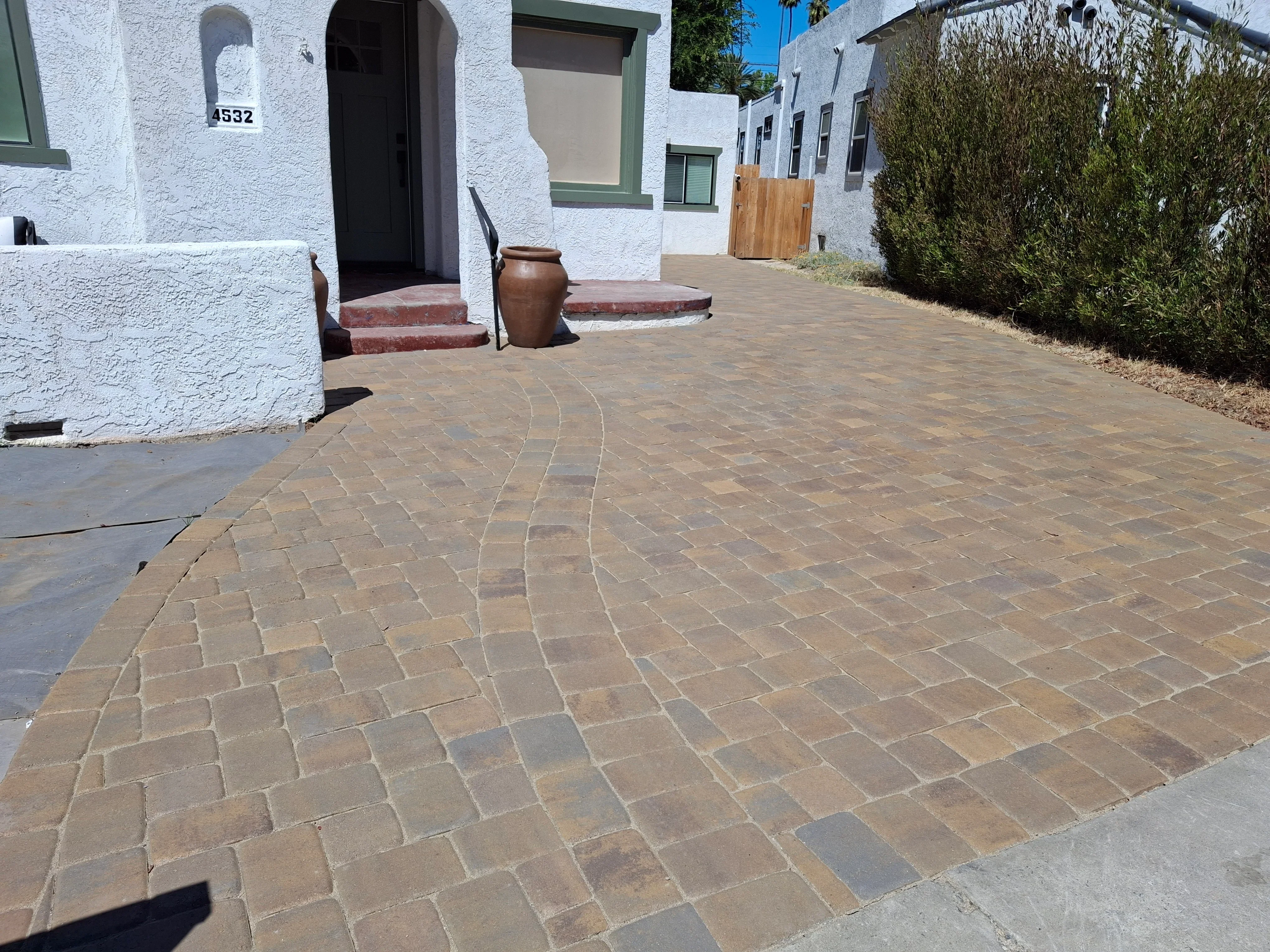 Curved concrete paver courtyard with running bond pattern in warm earth tones
