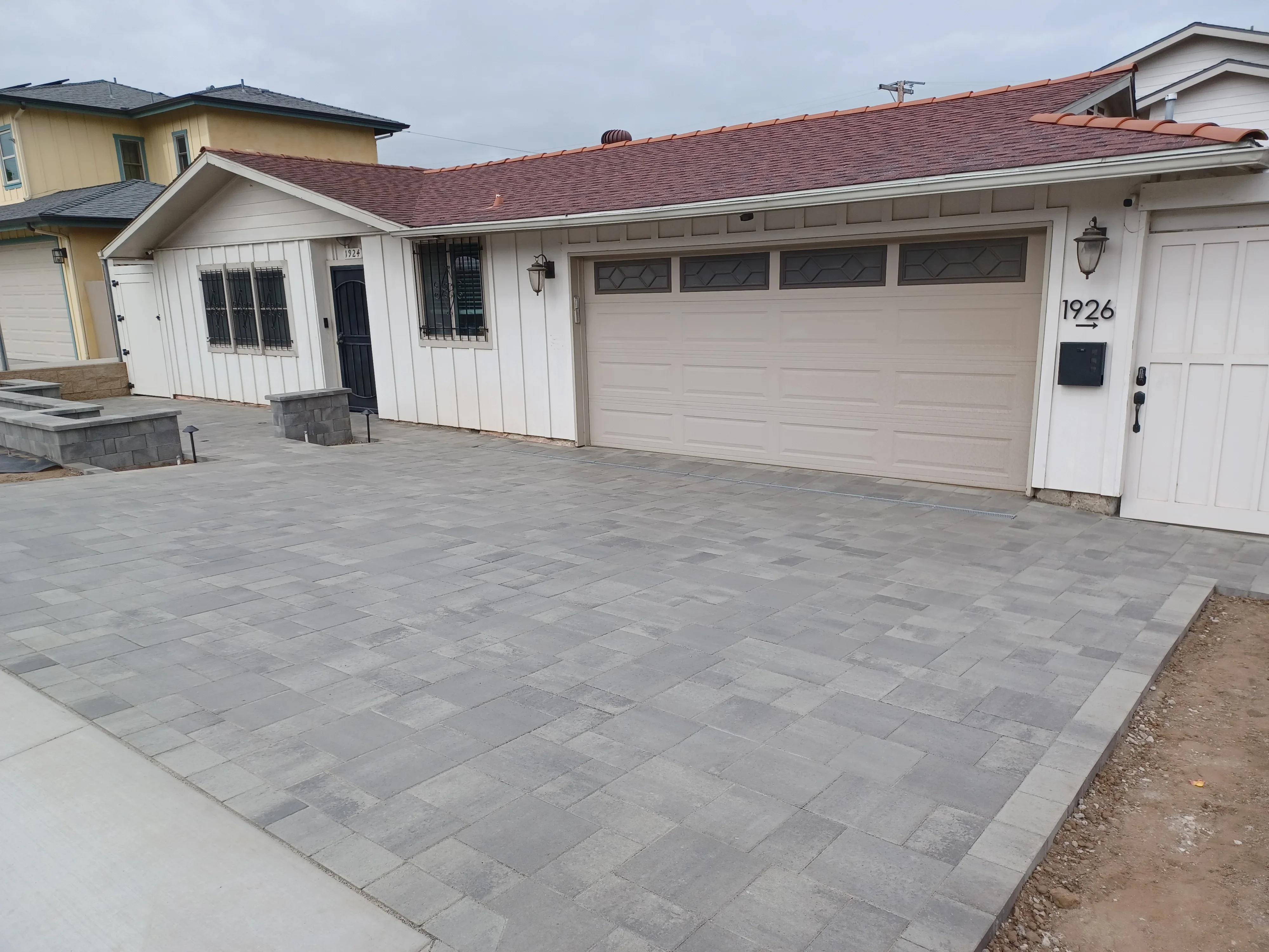 Gray permeable concrete pavers installed in running bond pattern with border edging on residential driveway