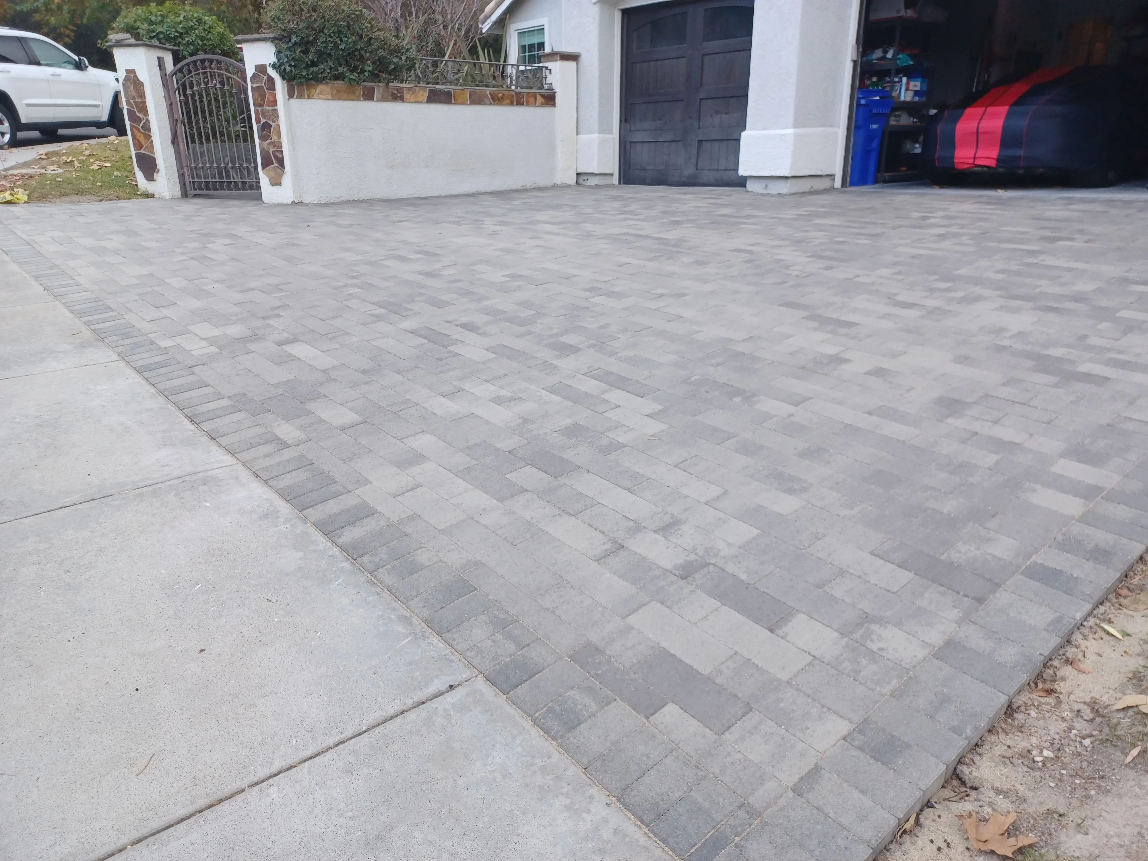 Gray and charcoal permeable pavers in herringbone pattern with decorative border stripe