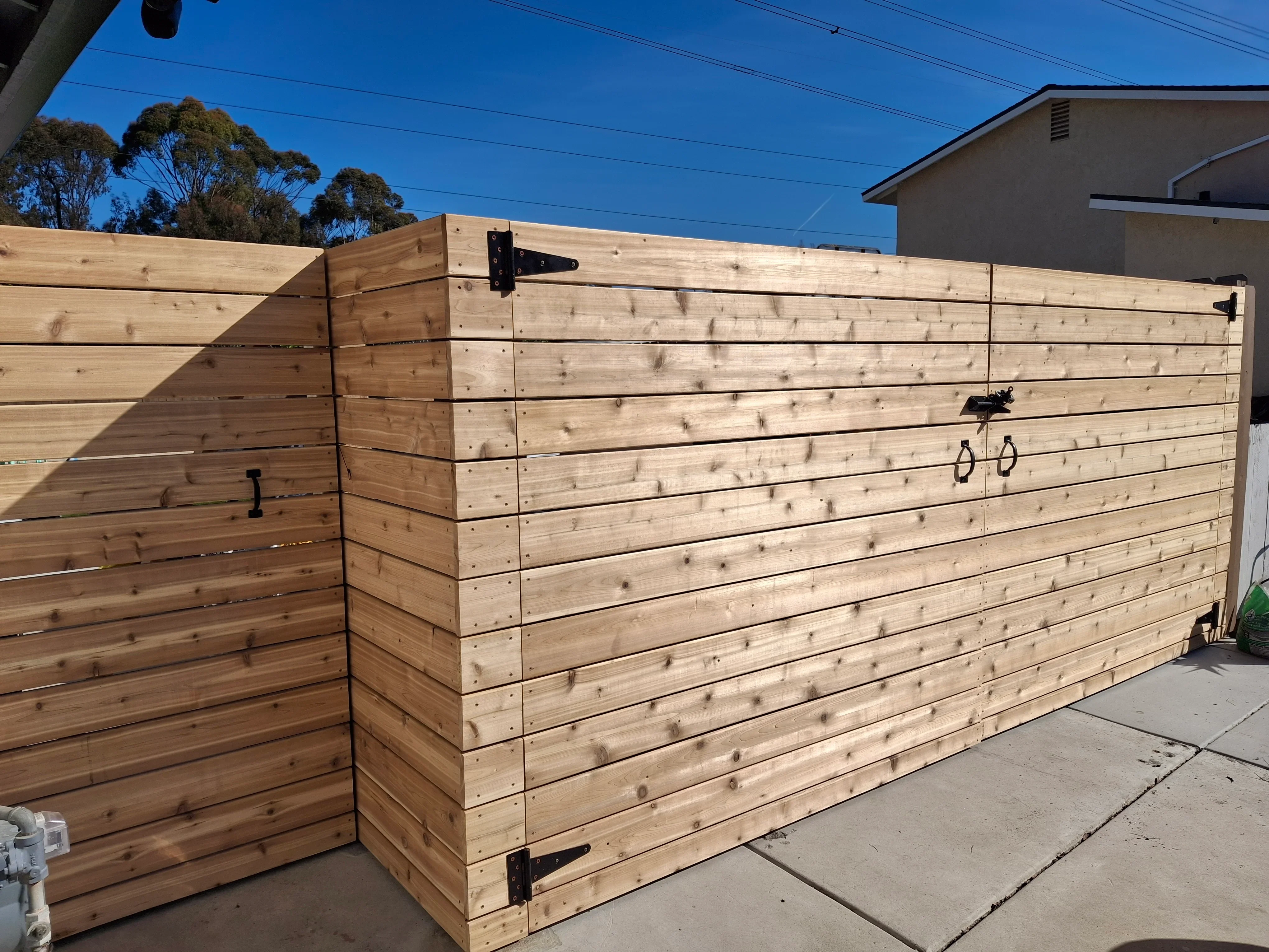 Horizontal cedar wood fence with black metal hinges and gate hardware