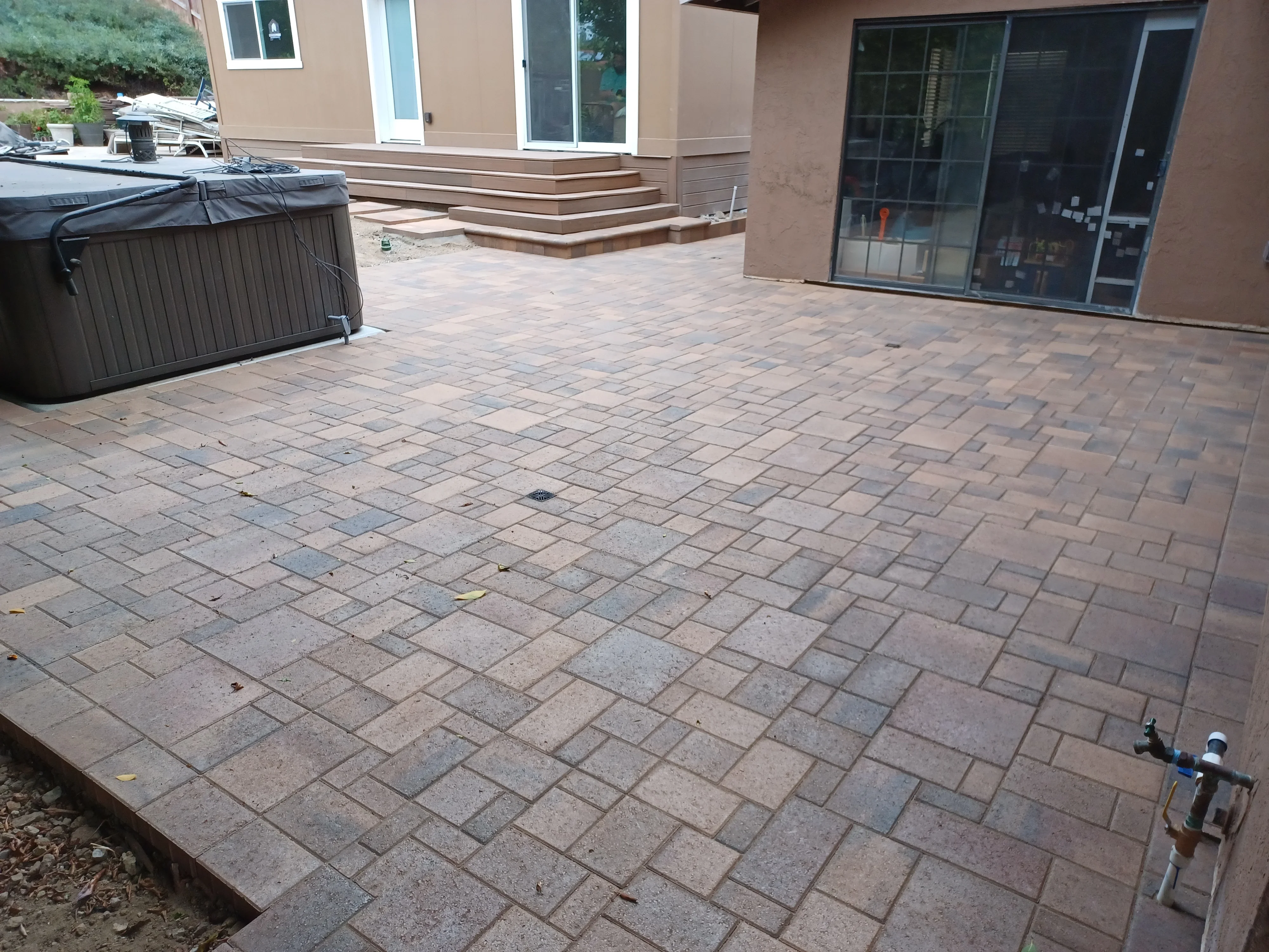Herringbone paver patio with warm-toned concrete pavers and integrated drainage