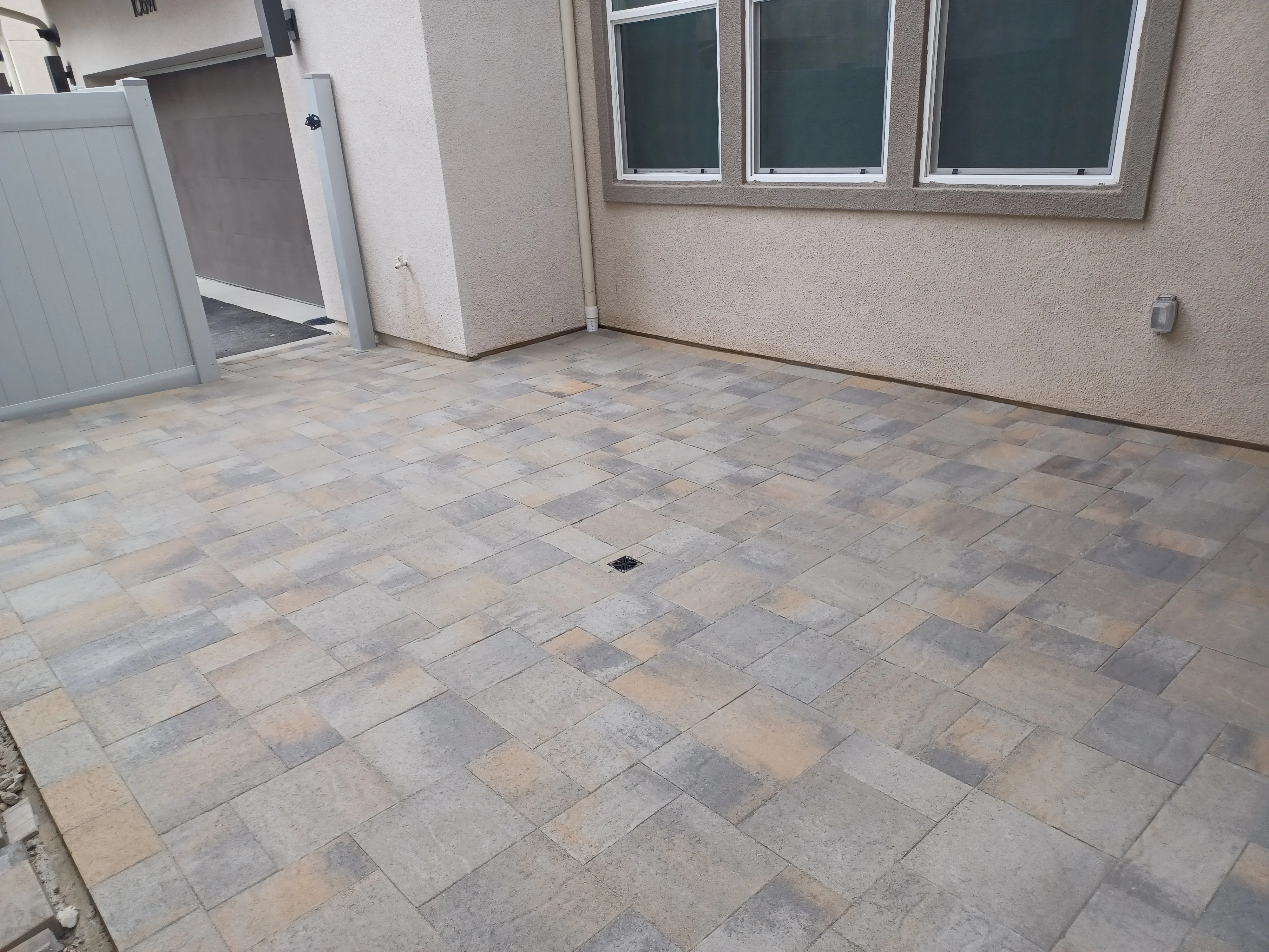 Permeable pavers in running bond pattern with mixed gray and tan tones on residential patio