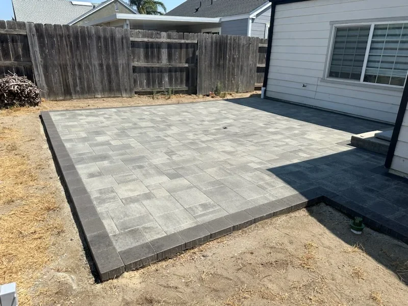 Gray permeable pavers in running bond pattern with dark border edging on residential patio