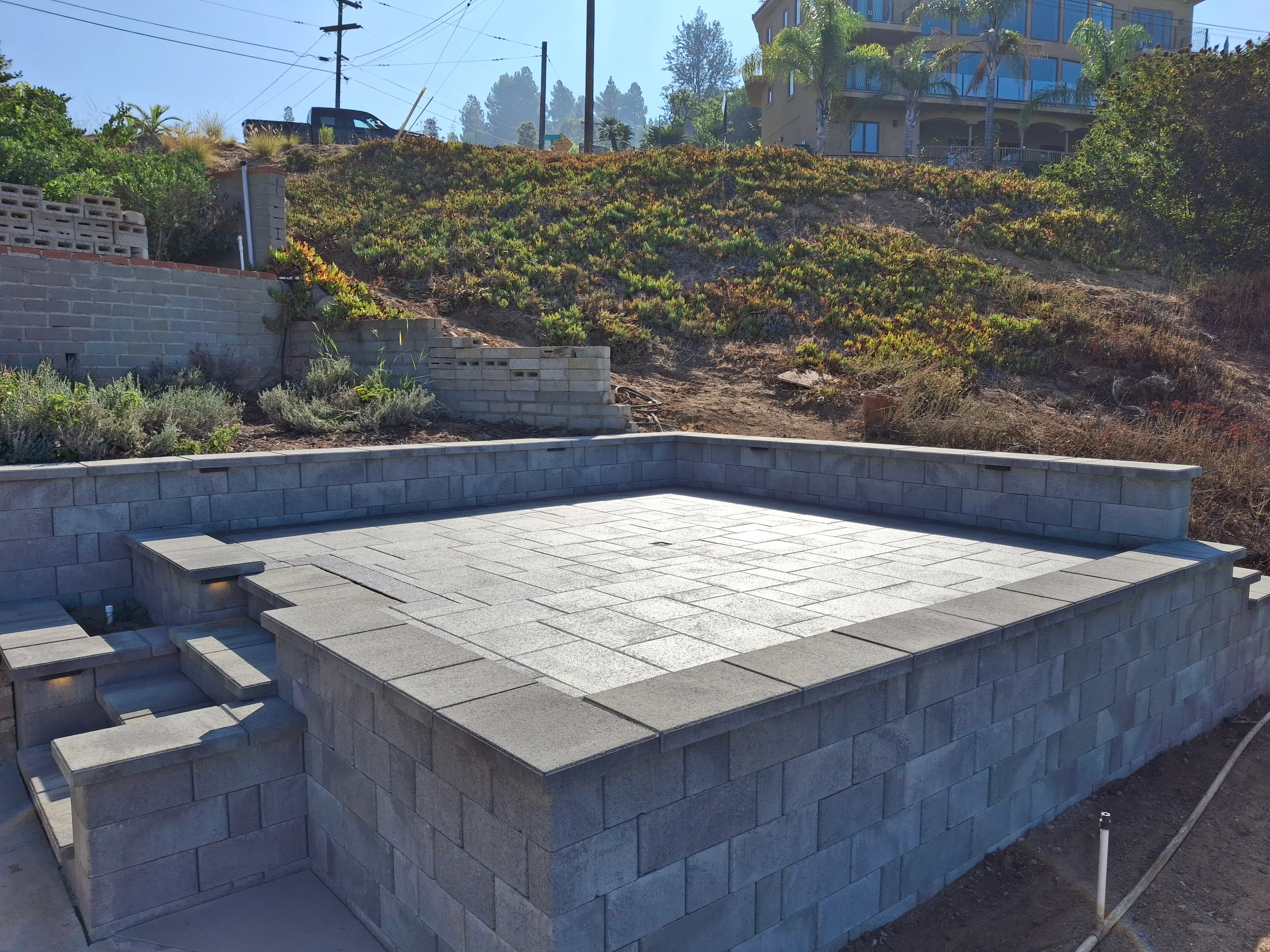 Concrete paver sunken patio with concrete block retaining walls and built-in seating ledges
